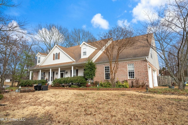 cape cod house with a porch, a garage, and a front lawn