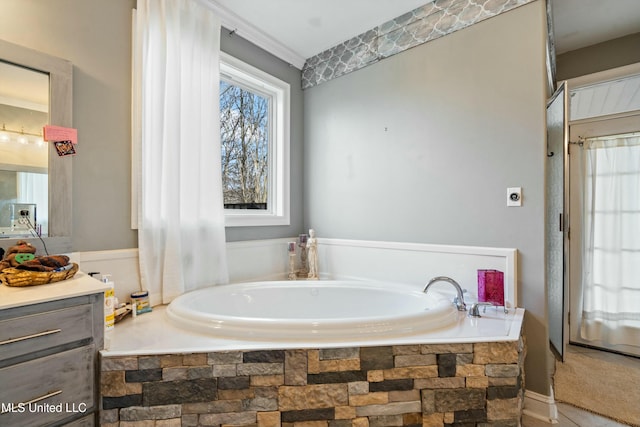 bathroom with vanity and tiled tub