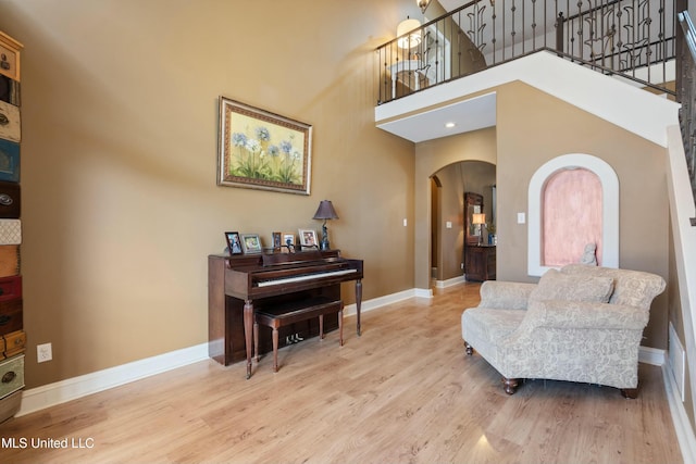 living area with wood-type flooring and a high ceiling