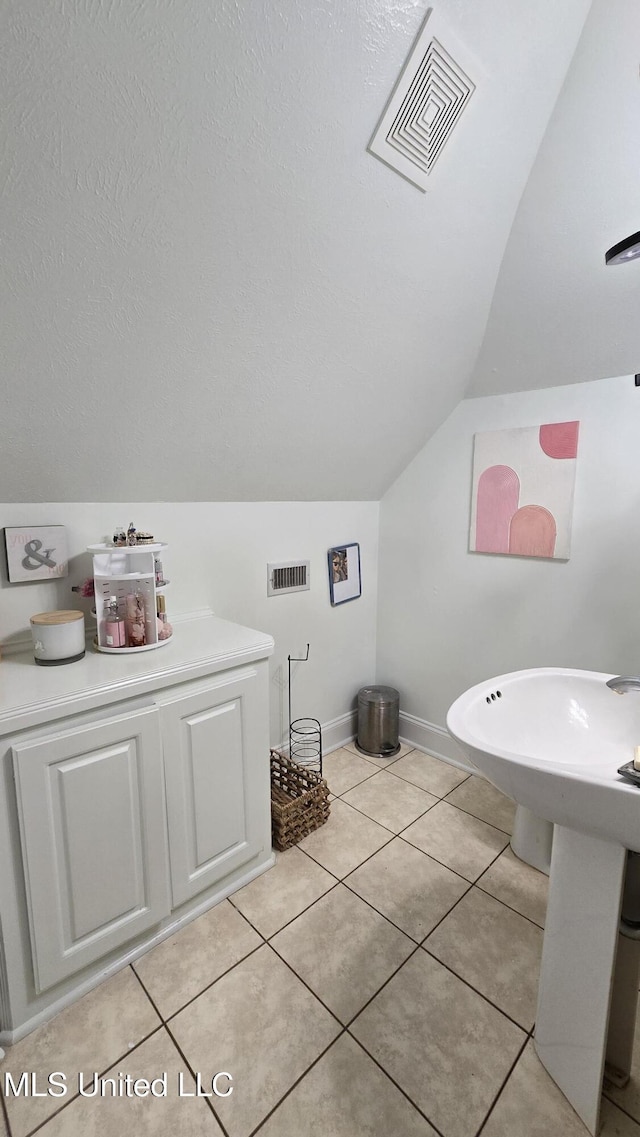 312 Grandview Ct, Pearl, MS 39208 - bathroom with vaulted ceiling, tile patterned flooring, and baseboards