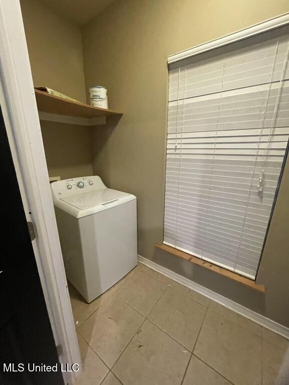 washroom featuring washer / dryer and light tile patterned flooring