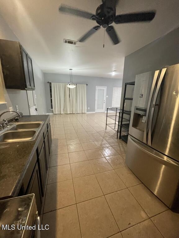 kitchen with sink, stainless steel refrigerator with ice dispenser, ceiling fan, light tile patterned floors, and dark brown cabinets