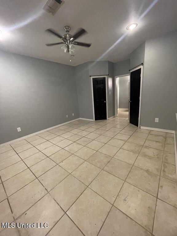 tiled spare room featuring ceiling fan