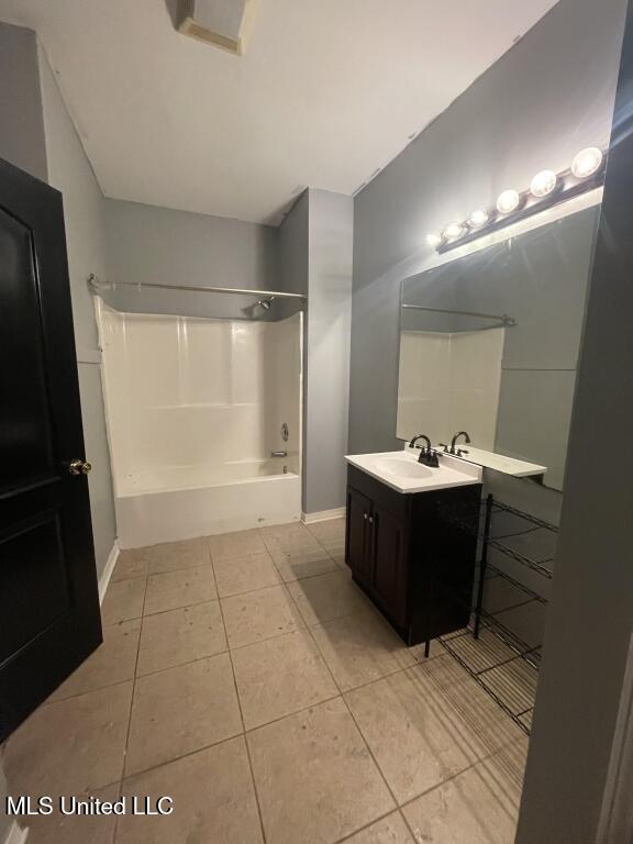 bathroom with shower / washtub combination, vanity, and tile patterned flooring