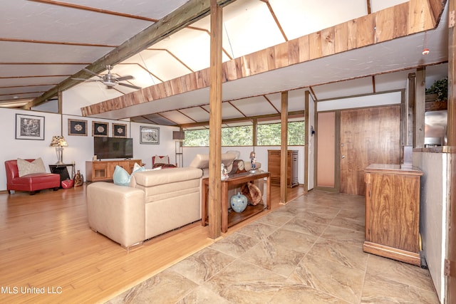 living room with ceiling fan and lofted ceiling with beams