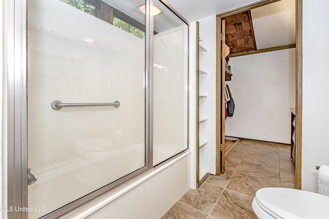 bathroom with combined bath / shower with glass door and toilet