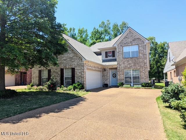 211 Fairway Trace Dr, Hernando, MS 38632 - traditional-style home with concrete driveway, an attached garage, and brick siding