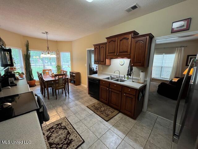 211 Fairway Trace Dr, Hernando, MS 38632 - kitchen with a sink, light countertops, a textured ceiling, black dishwasher, and light tile patterned floors