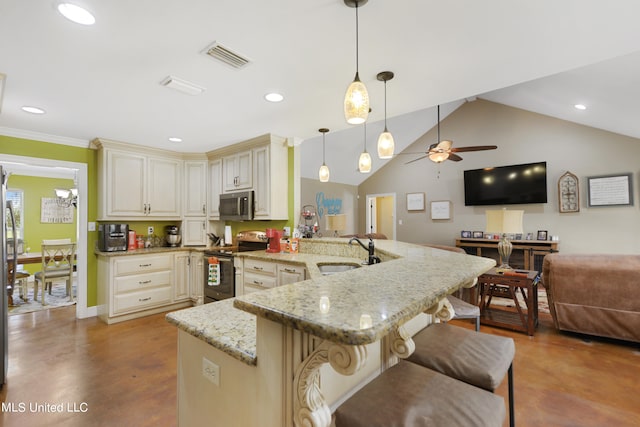 kitchen featuring appliances with stainless steel finishes, sink, kitchen peninsula, hanging light fixtures, and vaulted ceiling