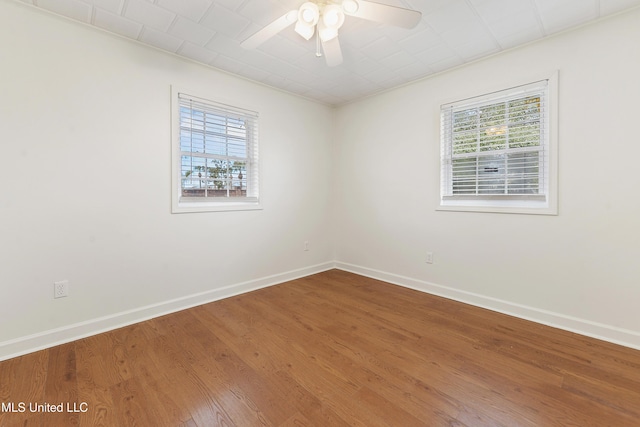 unfurnished room featuring ceiling fan, plenty of natural light, and wood-type flooring