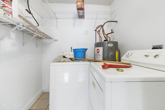 laundry area with washer and clothes dryer, electric water heater, and light tile patterned flooring