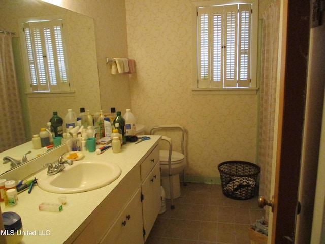 bathroom with tile patterned flooring, vanity, and toilet