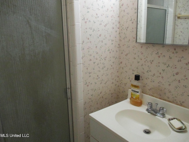 bathroom featuring vanity and a shower with shower door