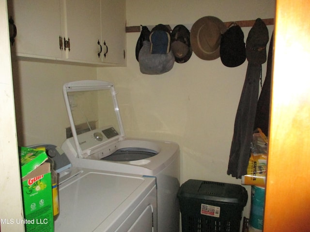 washroom featuring washer and clothes dryer and cabinets