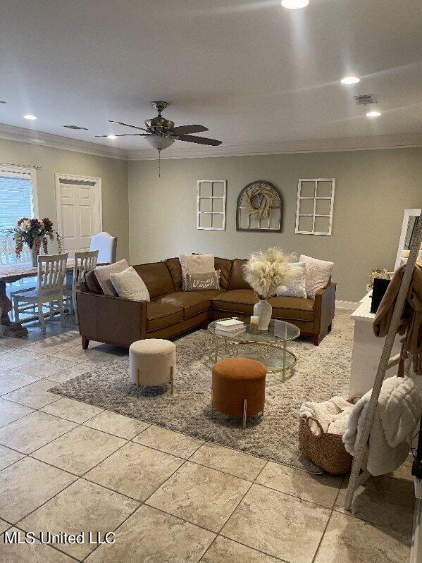 living room with ornamental molding and ceiling fan