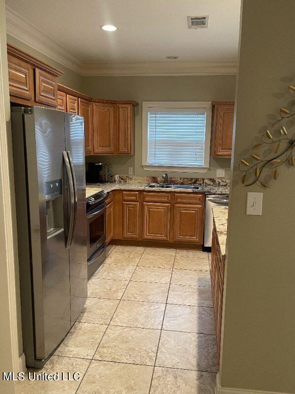 kitchen featuring ornamental molding, sink, light tile patterned flooring, and stainless steel appliances