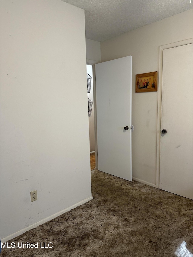 spare room featuring carpet floors and a textured ceiling