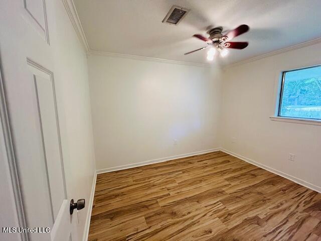 810 Louis Wilson Dr, Brandon, MS 39042 - spare room featuring wood finished floors, ornamental molding, a ceiling fan, and baseboards