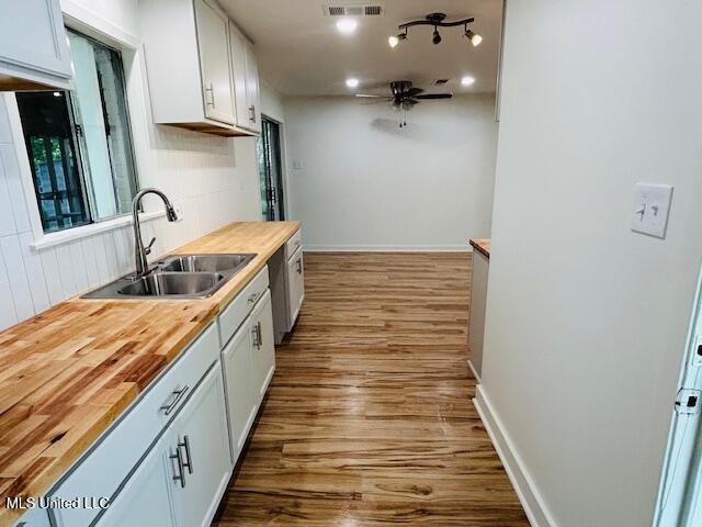 810 Louis Wilson Dr, Brandon, MS 39042 - kitchen with a sink, butcher block countertops, wood finished floors, and a ceiling fan