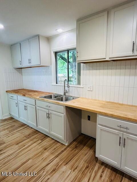 810 Louis Wilson Dr, Brandon, MS 39042 - kitchen featuring wood counters, a sink, light wood-style flooring, tasteful backsplash, and recessed lighting