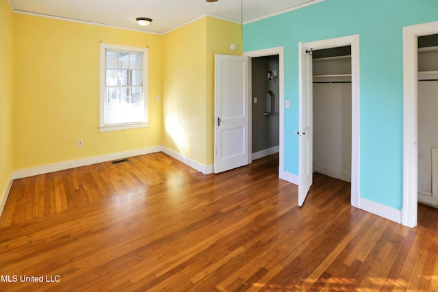 unfurnished bedroom with crown molding and dark hardwood / wood-style floors