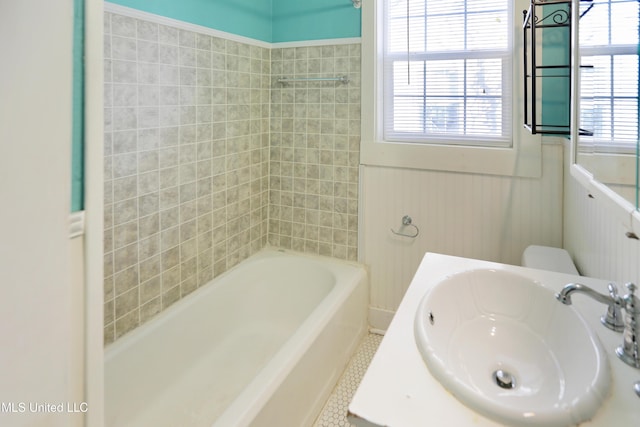 full bathroom with tile patterned floors, toilet, tiled shower / bath, and sink