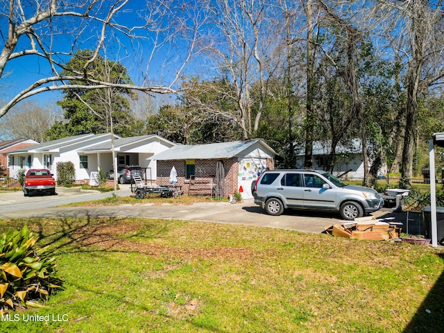 view of front facade with a front yard, concrete driveway, and brick siding