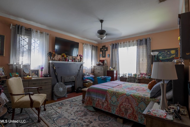 bedroom featuring wood finished floors, a ceiling fan, and crown molding