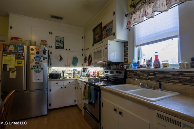 kitchen featuring appliances with stainless steel finishes, light countertops, white cabinetry, and backsplash