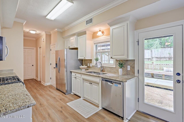 103 Cavitt Cv, Clinton, MS 39056 - kitchen featuring stainless steel appliances, a sink, white cabinets, light wood-type flooring, and ornamental molding