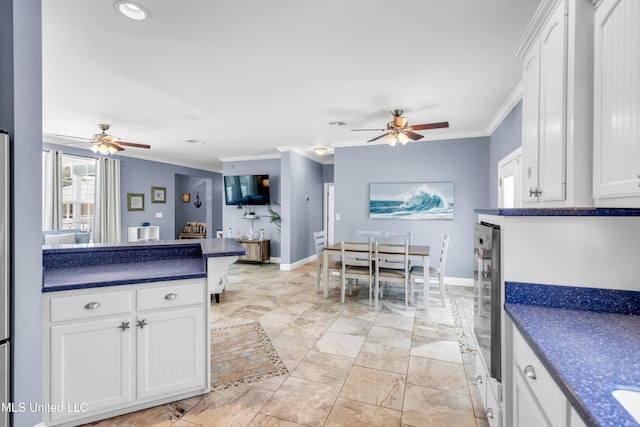112 Vista Dr, Pass Christian, MS 39571 - kitchen with a ceiling fan, dark countertops, crown molding, and white cabinetry