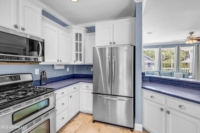 112 Vista Dr, Pass Christian, MS 39571 - kitchen featuring appliances with stainless steel finishes, dark countertops, white cabinetry, and glass insert cabinets