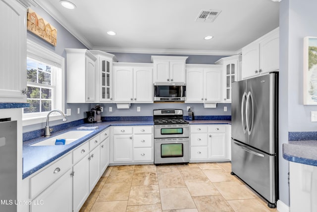 112 Vista Dr, Pass Christian, MS 39571 - kitchen featuring appliances with stainless steel finishes, white cabinets, glass insert cabinets, crown molding, and dark countertops