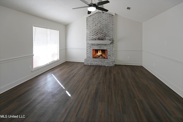 unfurnished living room with lofted ceiling, a fireplace, dark hardwood / wood-style flooring, and plenty of natural light