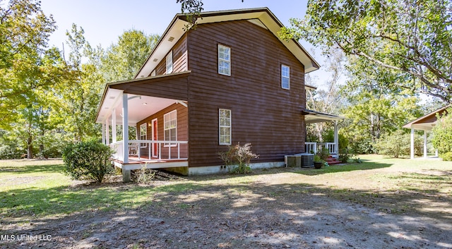 view of side of home with central air condition unit, a yard, and a sunroom