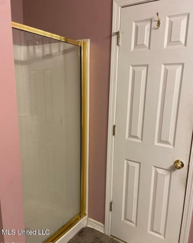 bathroom with a shower with door