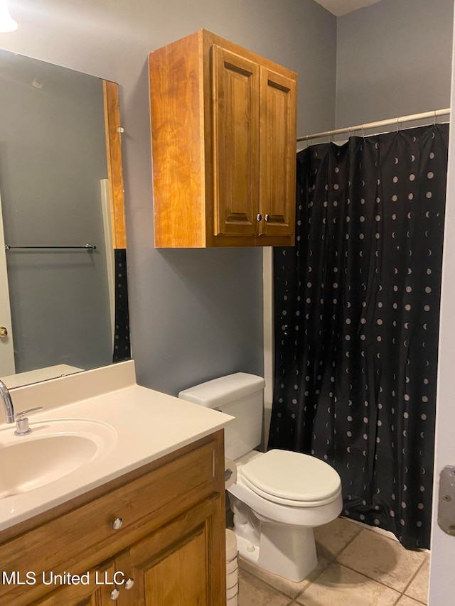 bathroom with vanity, toilet, tile patterned floors, and a shower with shower curtain