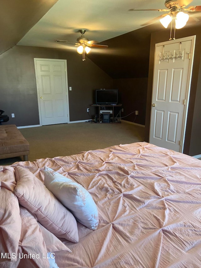 carpeted bedroom with ceiling fan and vaulted ceiling