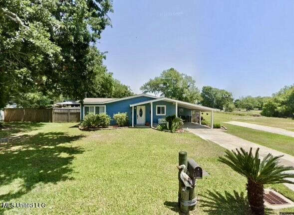 view of front of property with a front yard and a carport