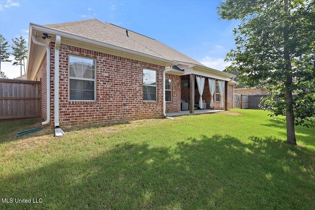 1235 Cutter Ln, Brandon, MS 39047 - back of house with brick siding, a fenced backyard, a patio, and roof with shingles