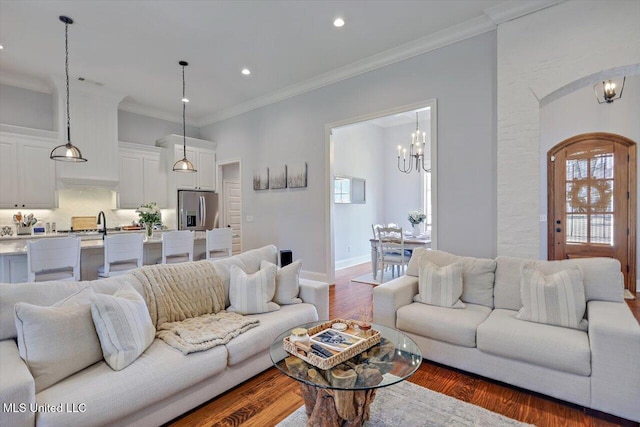1235 Cutter Ln, Brandon, MS 39047 - living room with a chandelier, dark wood-type flooring, crown molding, recessed lighting, and arched walkways