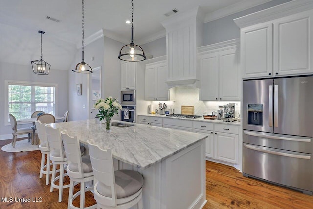1235 Cutter Ln, Brandon, MS 39047 - kitchen featuring stainless steel appliances, white cabinets, a kitchen island with sink, crown molding, and backsplash