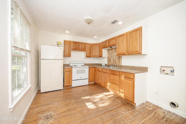 2411 12th St, Pascagoula, MS 39567 - kitchen with white appliances, light wood-style flooring, a textured ceiling, recessed lighting, and tasteful backsplash