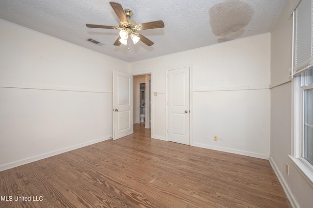 empty room with a textured ceiling, hardwood / wood-style flooring, and ceiling fan