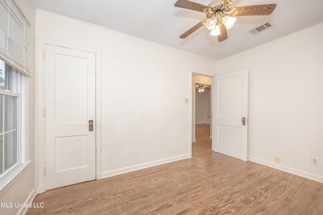 unfurnished room with light hardwood / wood-style floors, a textured ceiling, and ceiling fan