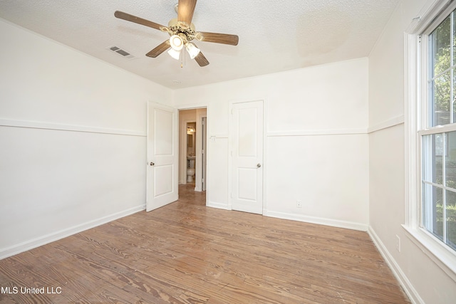 2411 12th St, Pascagoula, MS 39567 - unfurnished room with wood finished floors, healthy amount of natural light, a textured ceiling, and ceiling fan