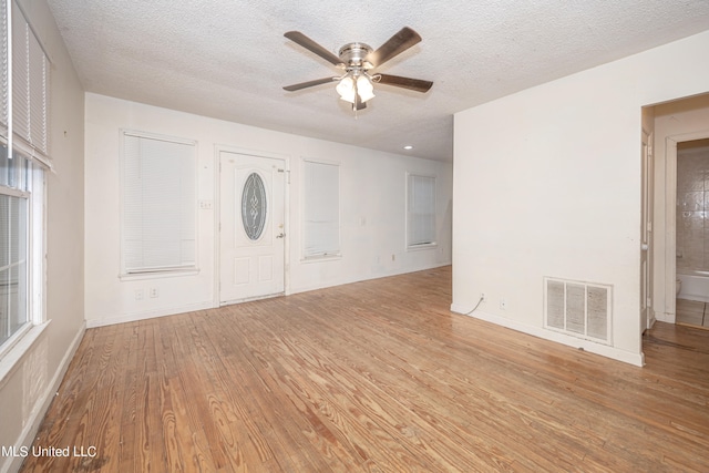 foyer entrance featuring ceiling fan, a textured ceiling, and light wood-type flooring