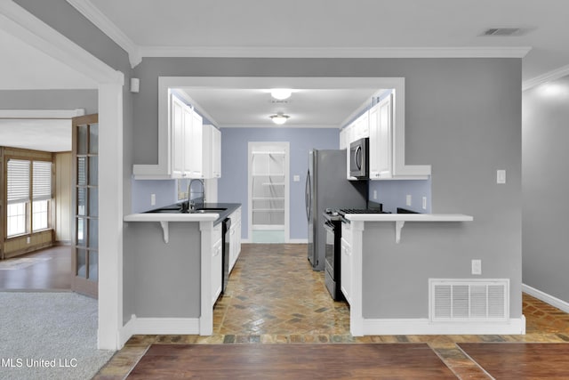 kitchen with ornamental molding, appliances with stainless steel finishes, a sink, and visible vents