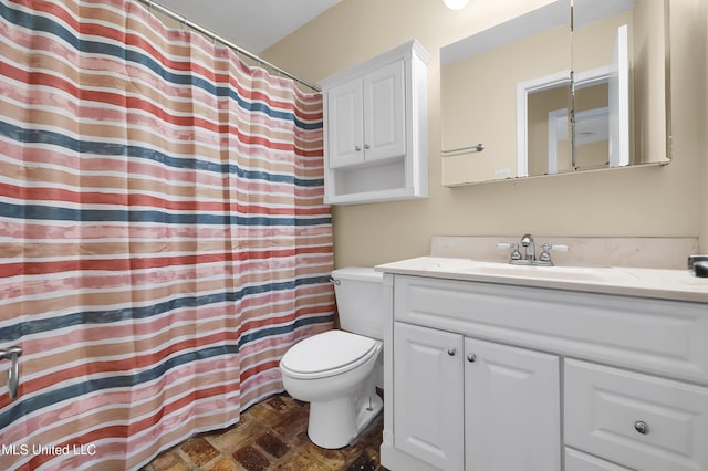 bathroom featuring curtained shower, vanity, and toilet