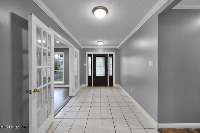 foyer entrance featuring french doors, crown molding, baseboards, and light tile patterned floors